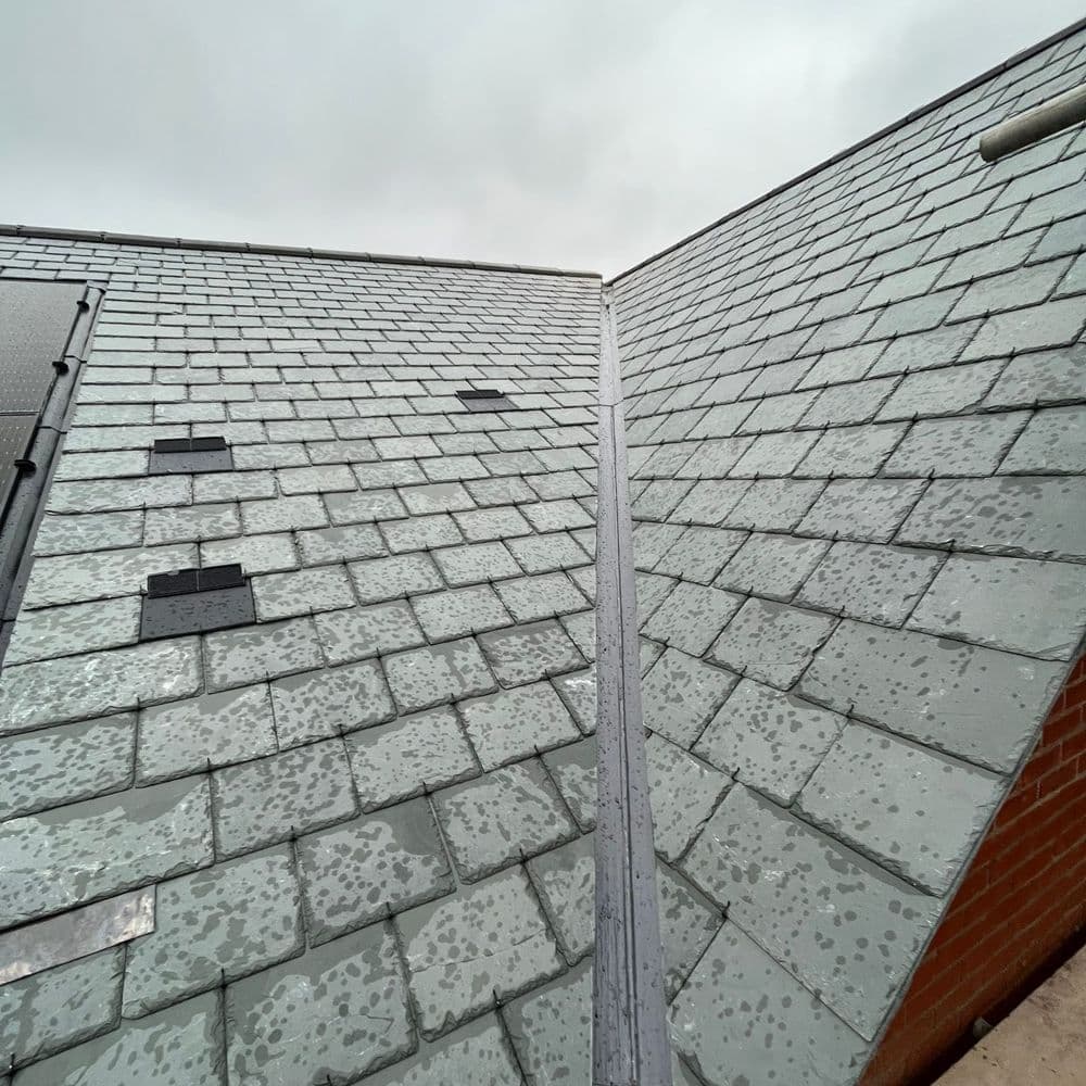 A slate roof with a new lead valley between two slopes