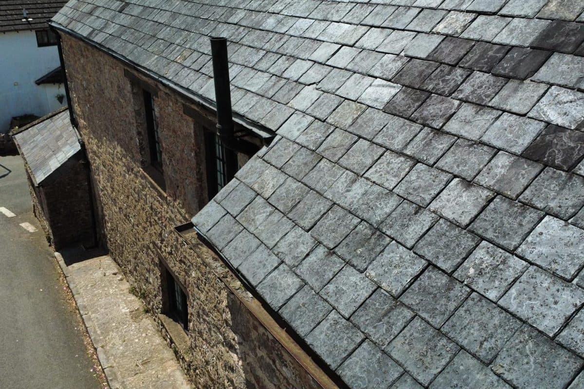 An aerial view along the slate roof of a stone building